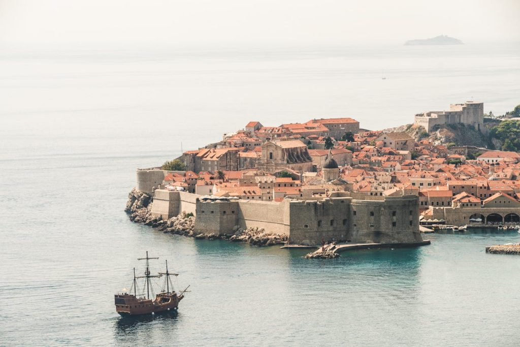 Stunning aerial photo of Dubrovniks old town and city walls by the Adriatic Sea.
